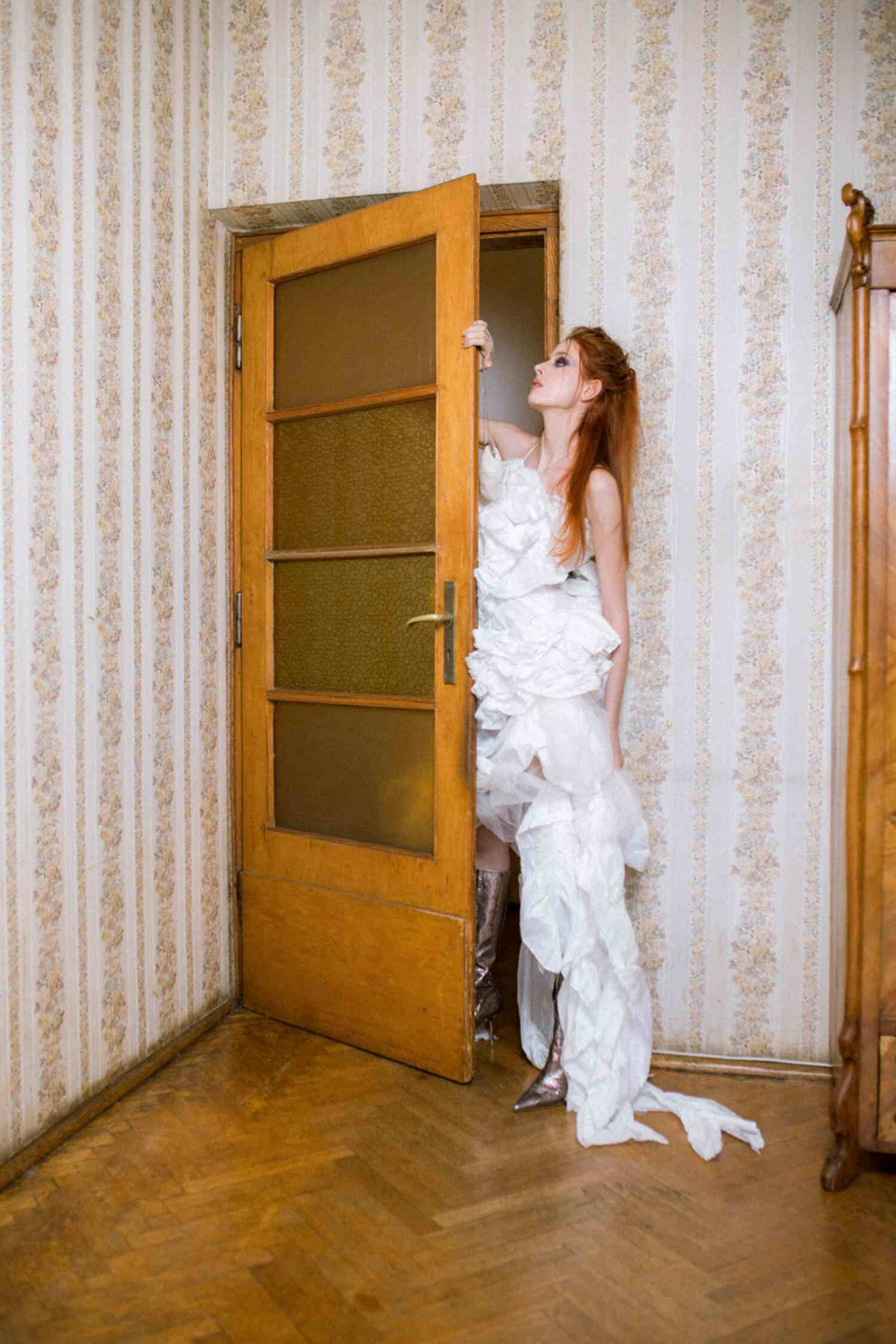 Model Weronika Siesicka wearing a dress by Magdalena Wilk-Dryło, Jimmy Choo boots, and a Dolce & Gabbana bag in a fashion editorial by Helena Bromboszcz.