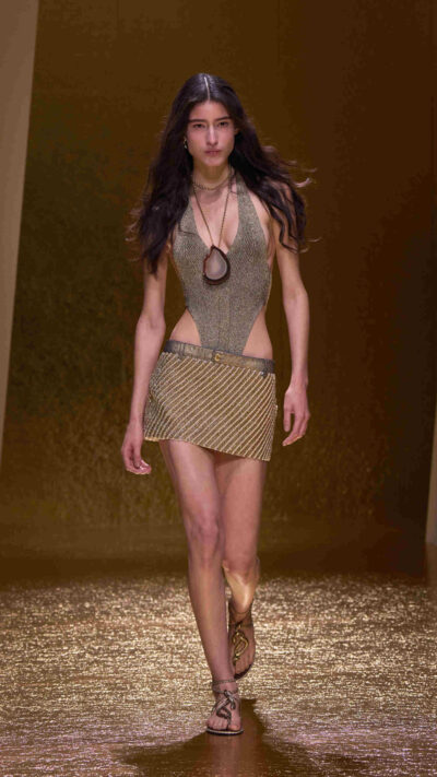 In Fausto Puglisi’s hands, Cavalli’s signature sensuality is not softened — it is sharpened. Animal prints appear as fierce whispers, metallic textures glint like armor under sunlight, and drapery cascades with Grecian drama. Each piece tells a story of independence — not curated for approval, but curated for the woman herself.