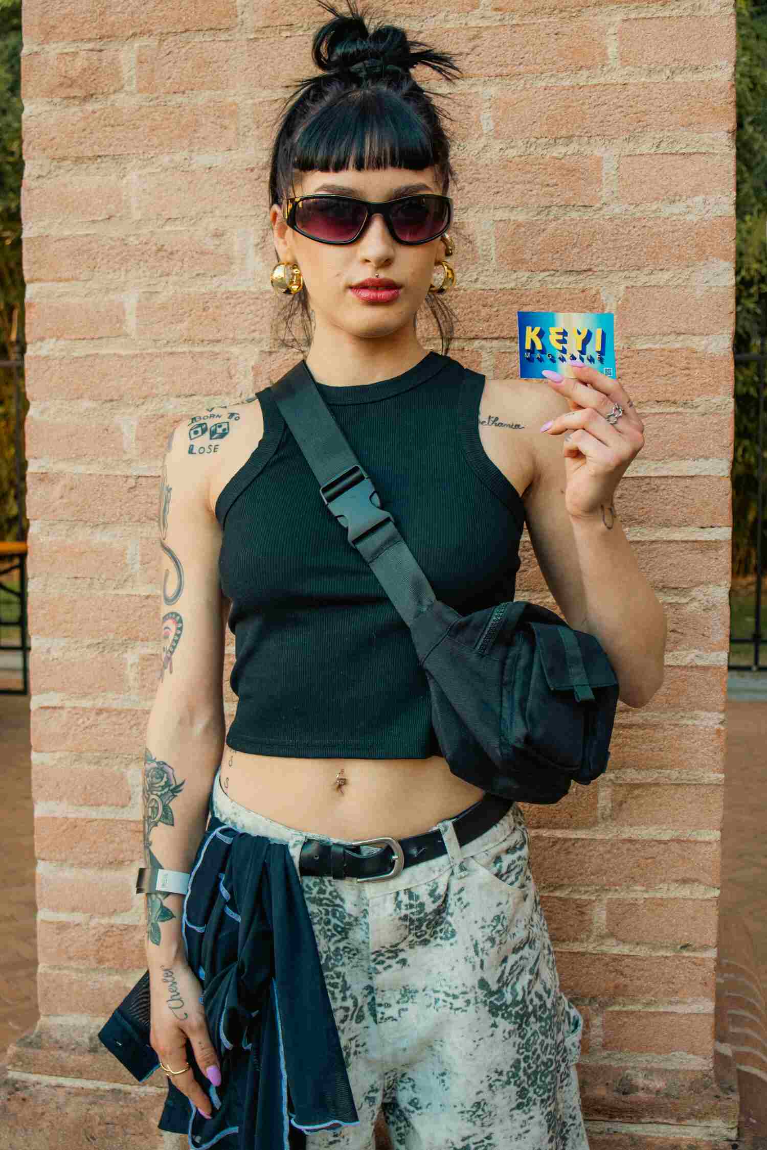 one of the people attending the festival holding a keyi sticker 